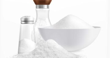 Sea salt realistic composition with piles of white salt in plates and glass jars with caps vector illustration